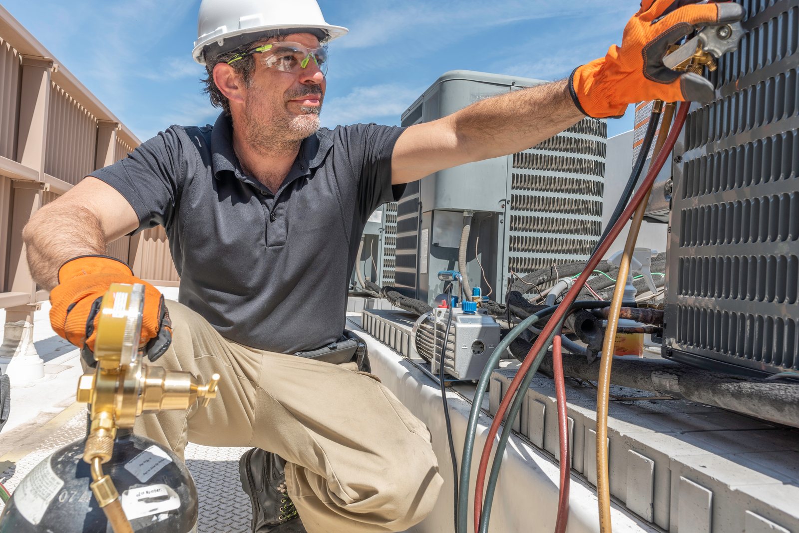 An AC Sky technician servicing a condenser unit in the Austin area
